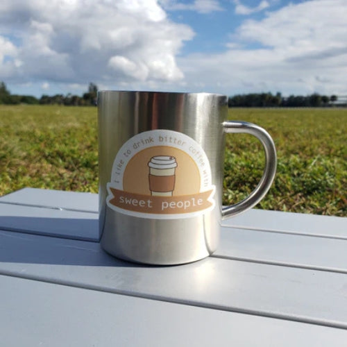 Cute coffee sticker on a stainless steel mug, reads “I like to drink bitter coffee with sweet people”