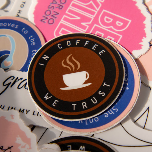 Round brown coffee sticker that reads “In Coffee We Trust,” surrounded by other aesthetic vinyl stickers